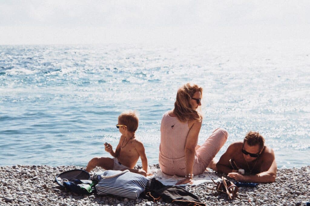 A family enjoys quality time on the beach near their hotel.
