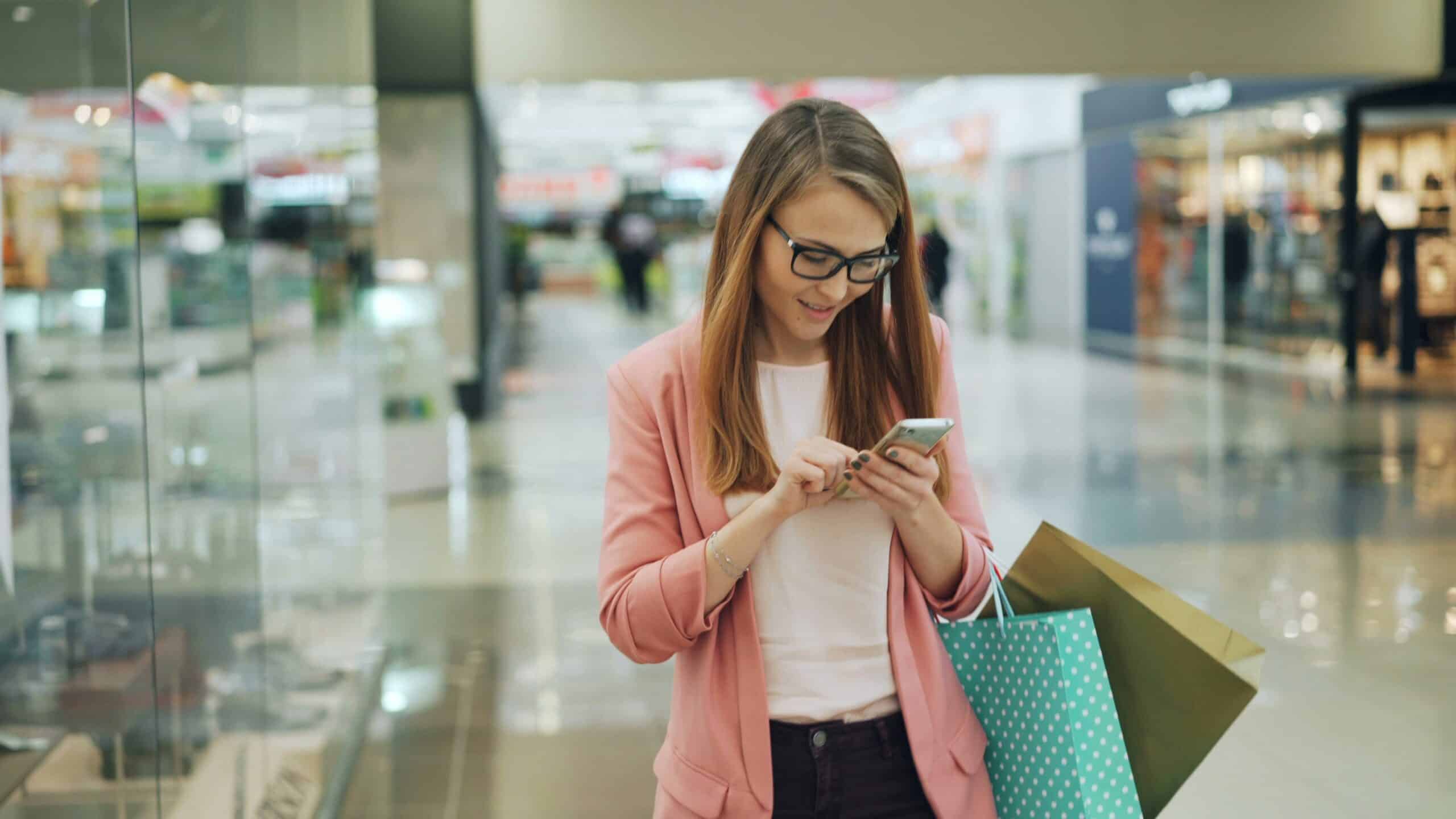 A traveler, while out shopping. uses SMS to communicate with her accommodation provider from her smartphone.